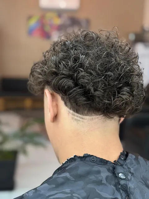 Cabelo cacheado com degradê e risco na Standard Barbearia